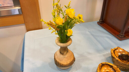 Turned flowerpot with yellow flowers