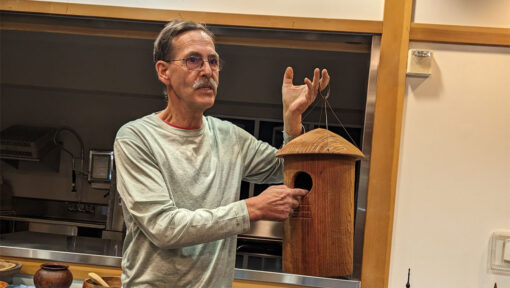 Kelly Smith holding a woodturned birdhouse