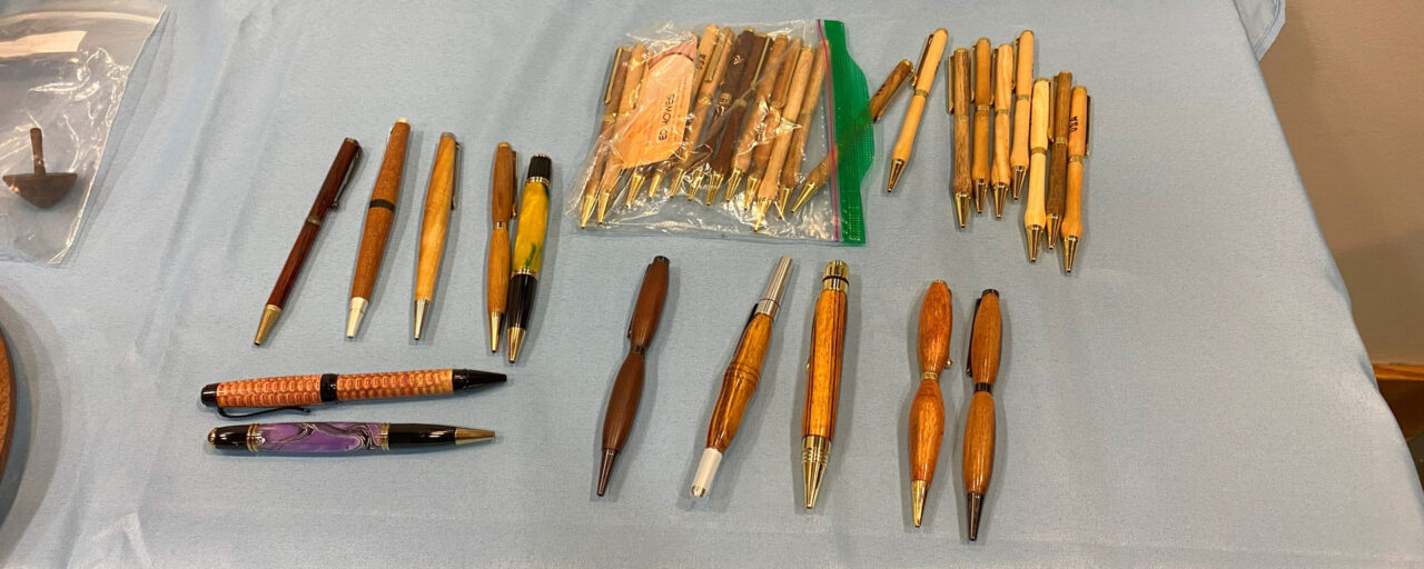 A table with a couple dozen turned pens