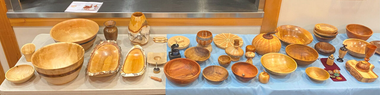 A display table with a couple dozen woodturned bowls and vases.