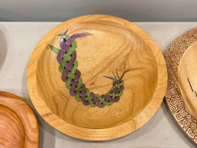 A wooden platter with burned and colored Celtic knot