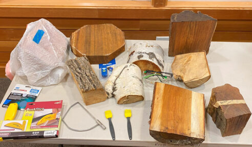 A table full of woodturning tools and wooden blanks used as a prizes for participation in president's challenge and show & tell.