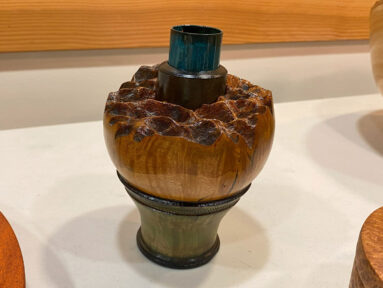 A decorative flower vase with a copper pipe insert.